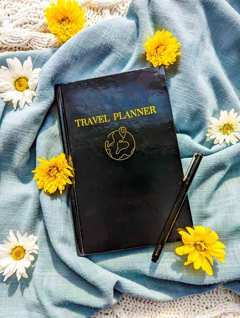A personal travel planner with flowers on a blue blanket.